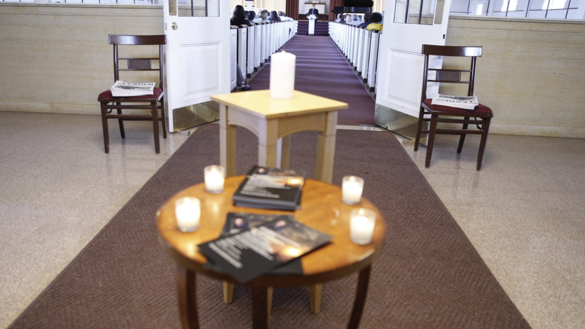 A table of programs and candles are featured in front of Ron Wiginton's memorial service.