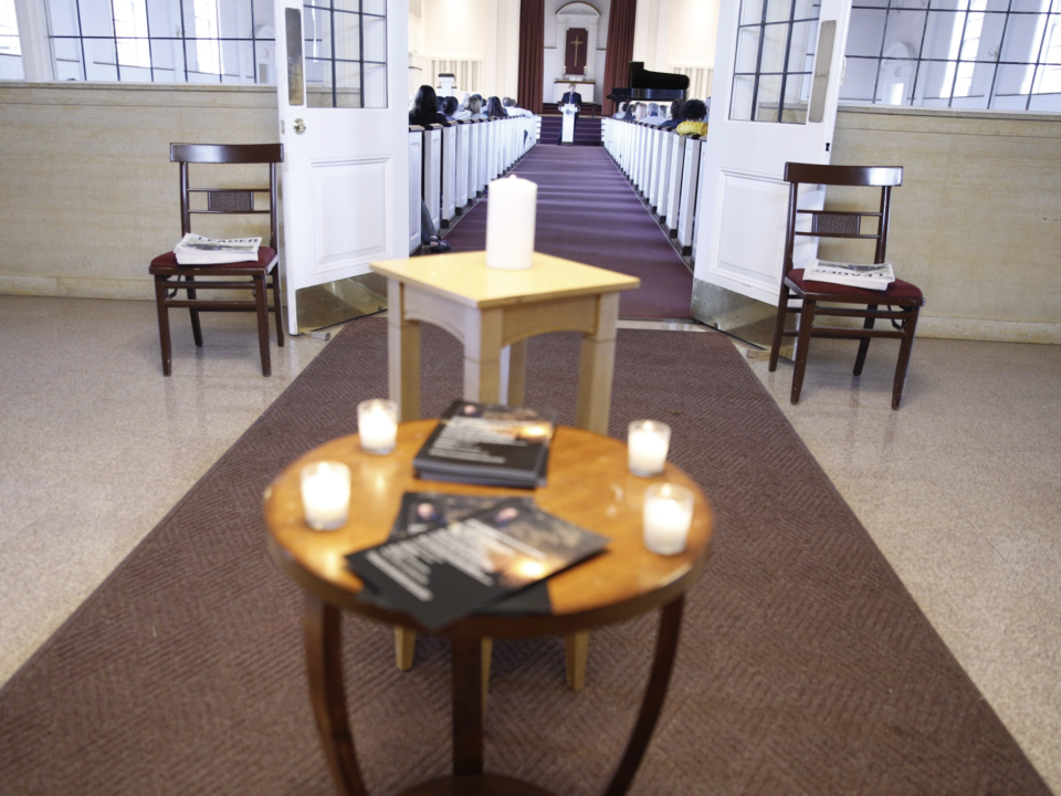 A table of programs and candles are featured in front of Ron Wiginton's memorial service.