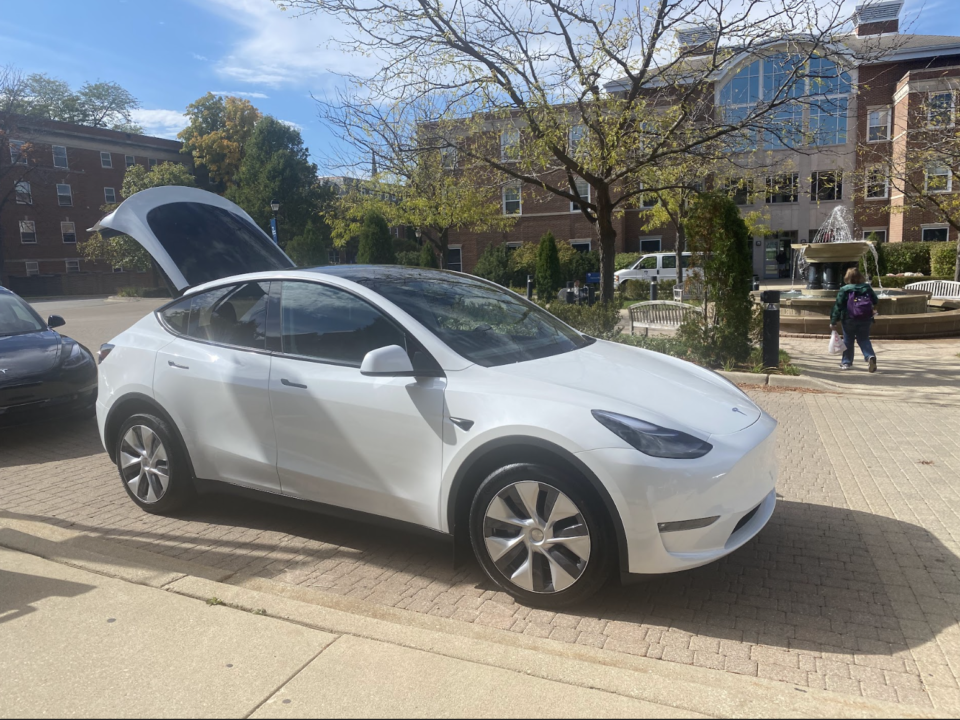 A Tesla vehicle is parked in front of the A.C. Buehler Library